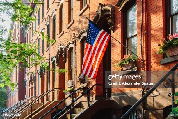 american flag on a townhouse in jersey city, new jersey - jersey city stock pictures, royalty-free photos & images