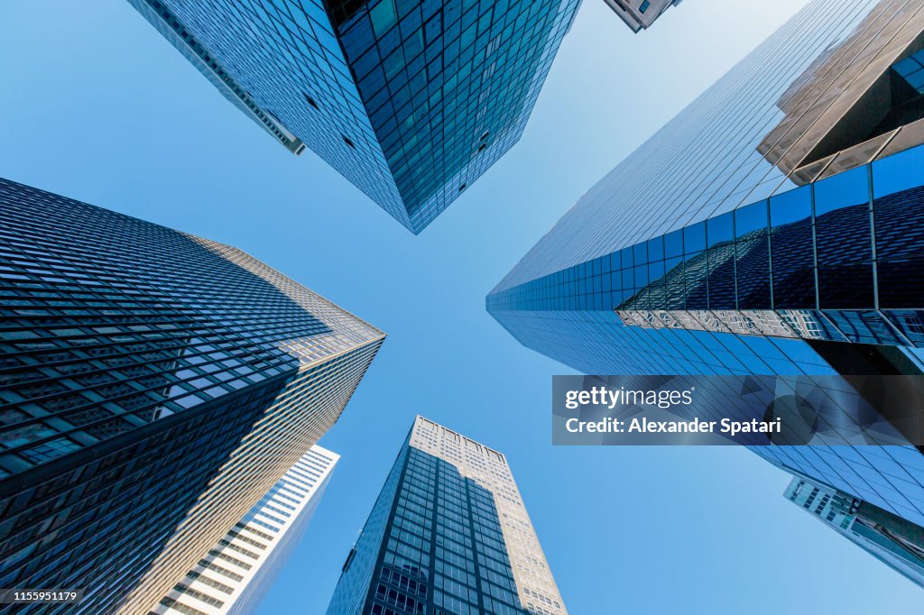 Low angle view of modern skyscrapers against clear blue sky in Manhattan Downtown, New York