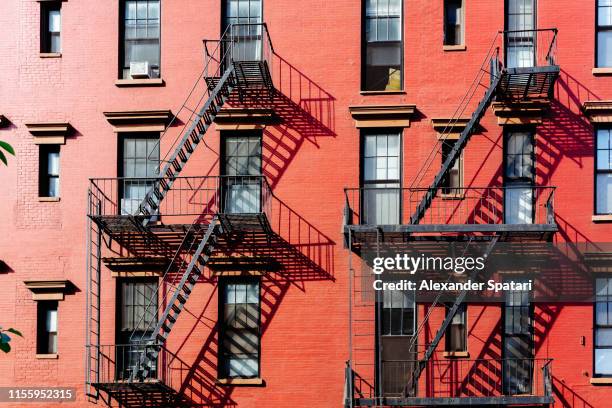 fire escape stairs on buildings in west village district, new york city - soho new york stockfoto's en -beelden