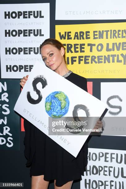 Stella McCartney poses with a sign readin 'SOS' during the presentation of Stella McCartney during the Milan Men's Fashion Week Spring/Summer 2020 on...