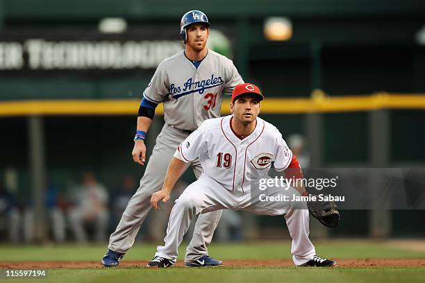 Joey Votto of the Cincinnati Reds defends first base as Jay Gibbons of the Los Angeles Dodgers takes a lead off first base at Great American Ball...