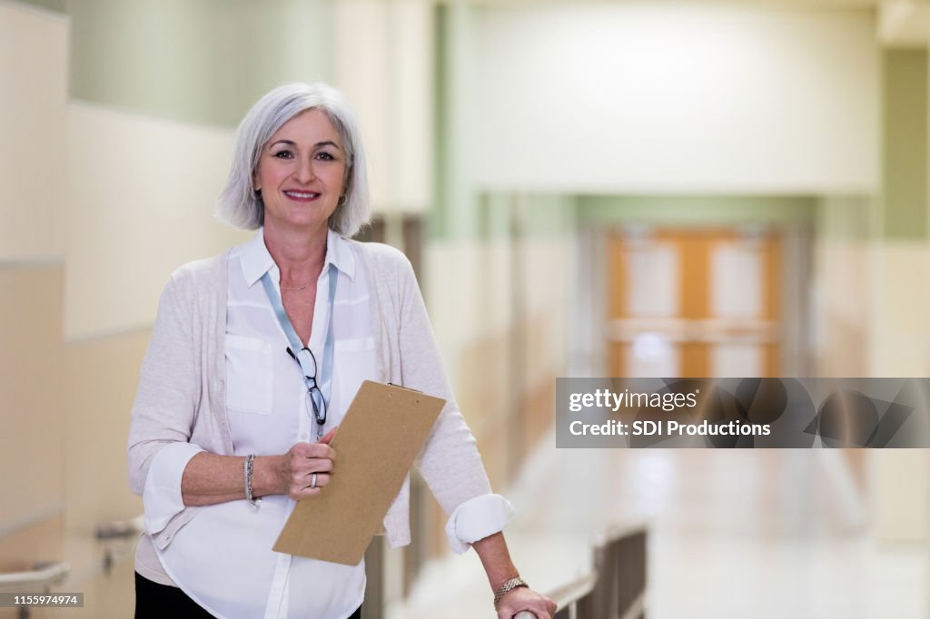 成熟した大人の学校のカウンセラーは、廊下で休憩を取ります