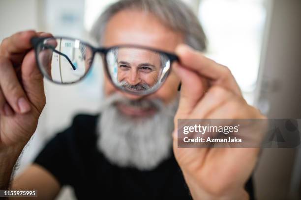 homem maduro que testa vidros novos - human eye - fotografias e filmes do acervo