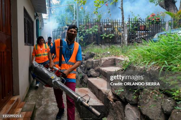 Employees of the Honduran Secretariat of Health and of the Permanent Contingency Committee take part in a fumigation operation to combat Aedes...