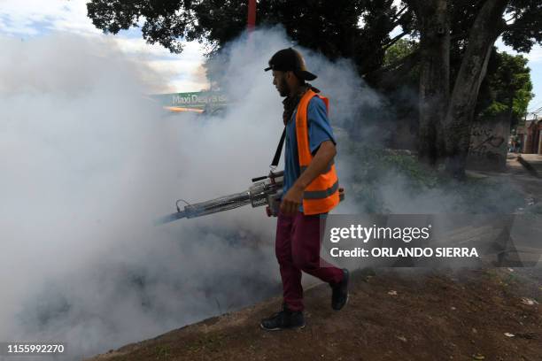 An employee of the Honduran Secretariat of Health takes part in a fumigation operation to combat Aedes aegypti, vector of the dengue fever, in...