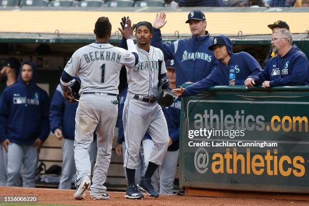 Tim Beckham of the Seattle Mariners celebrates with Mallex Smith after scoring on a sacrifice fly ball hit by Dee Gordon in the top of the fourth...