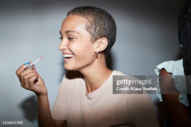 smiling woman applying lip gloss at home - lipgloss bildbanksfoton och bilder