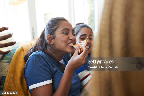 cheerful young woman eating slice of pizza - comer pizza imagens e fotografias de stock