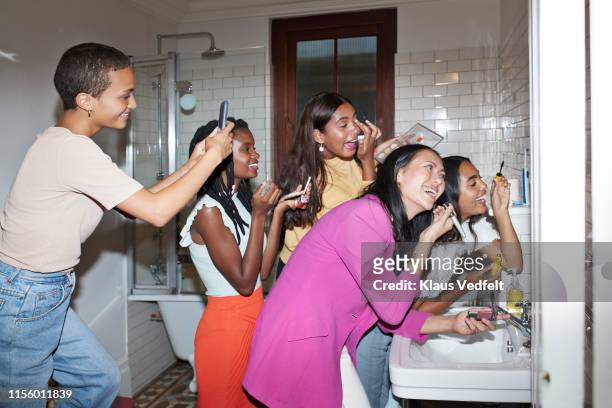 smiling woman photographing friends doing make-up - preparazione foto e immagini stock