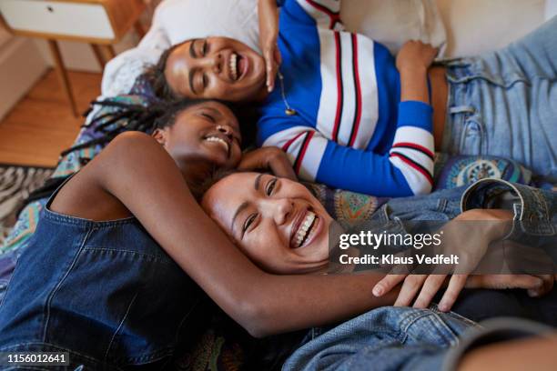 young female friends lying on bed at home - affectionate stock photos et images de collection