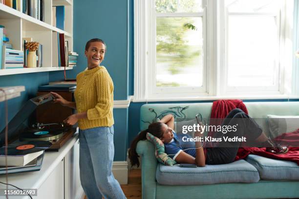 woman playing music and friend using phone - lying on back photos - fotografias e filmes do acervo