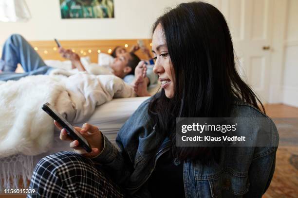 smiling woman text messaging on phone in bedroom - social media profile stock pictures, royalty-free photos & images