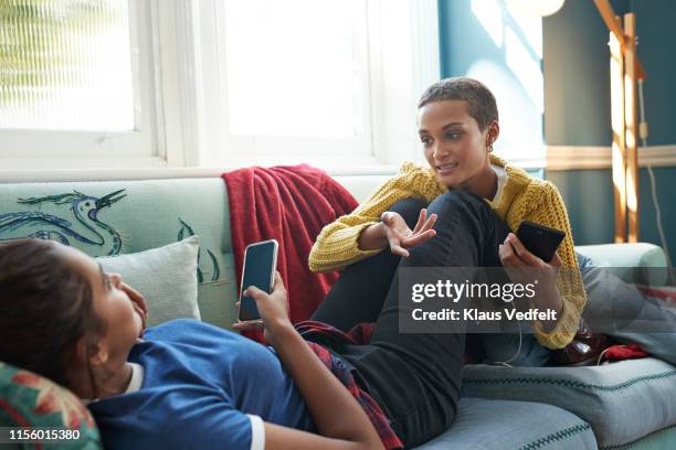 friends talking while resting on sofa at home - talk phone flat imagens e fotografias de stock