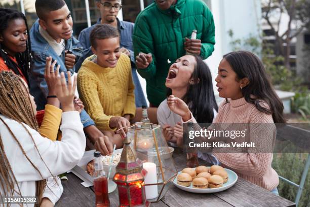 cheerful friends enjoying food at table - catching food stock pictures, royalty-free photos & images