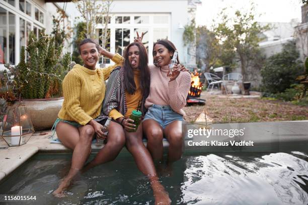 cheerful friends making faces at poolside in party - drinkwater kante stock-fotos und bilder