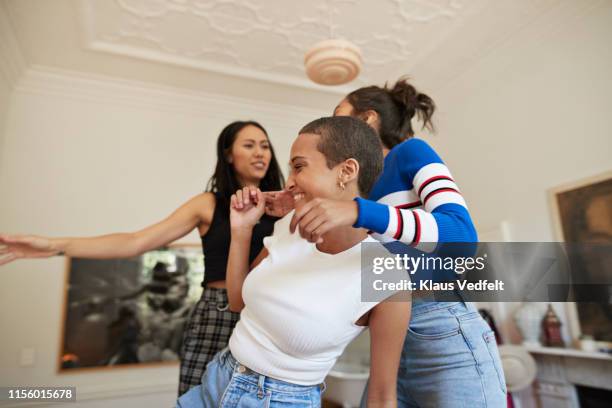 cheerful young female friends enjoying in bedroom - three people dancing stock pictures, royalty-free photos & images