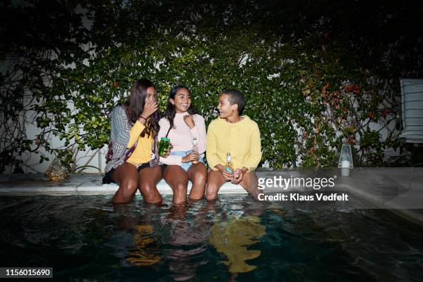happy young friends enjoying drinks at poolside - pool party night stock pictures, royalty-free photos & images