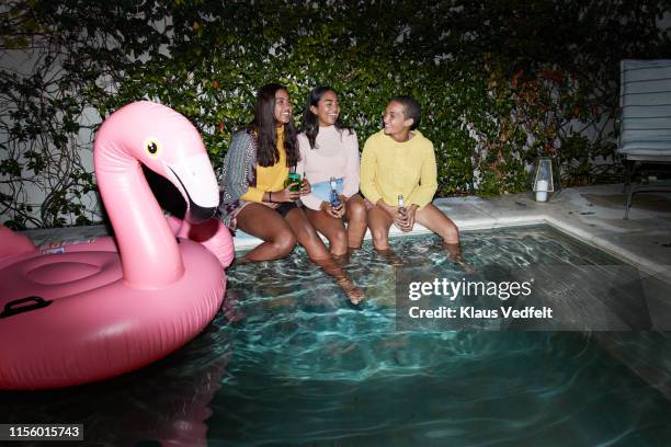 happy friends talking by inflatable raft in pool - pool party night stock pictures, royalty-free photos & images