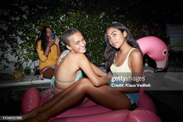 portrait of friends sitting on inflatable raft - pool party night stock pictures, royalty-free photos & images