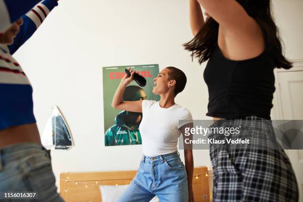 young woman singing and dancing with friends - dancing home stockfoto's en -beelden