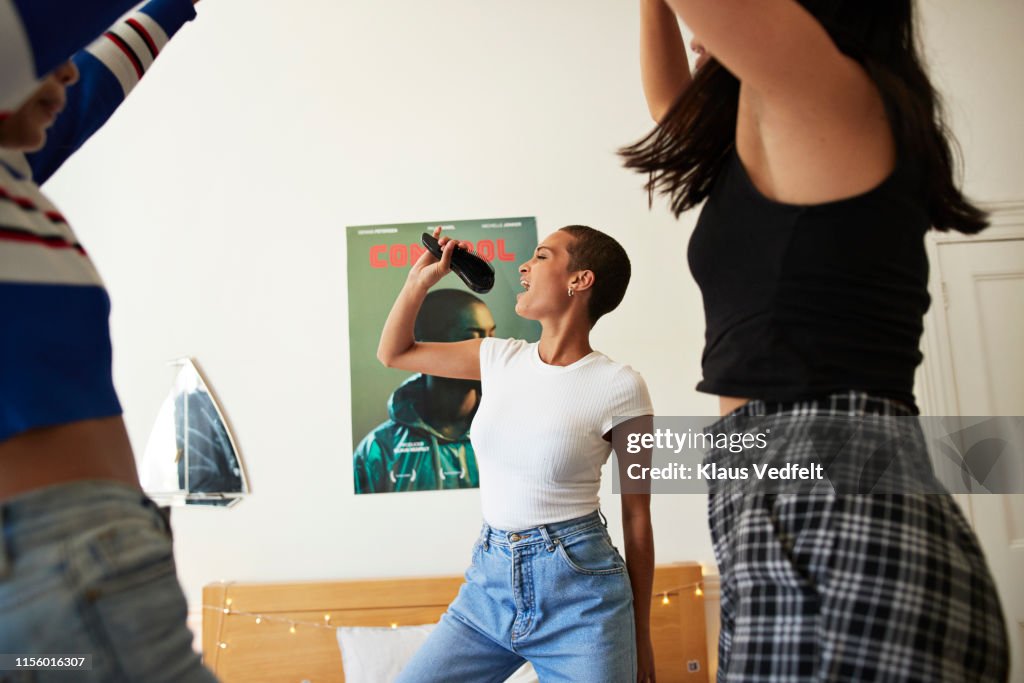 Young woman singing and dancing with friends