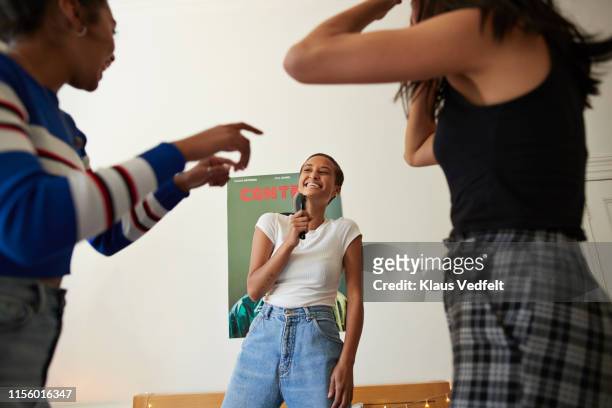 cheerful woman singing and dancing with friends - poster music stock-fotos und bilder