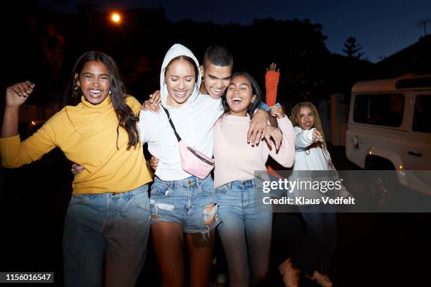 happy young friends dancing at night - group of friends walking along street fotografías e imágenes de stock