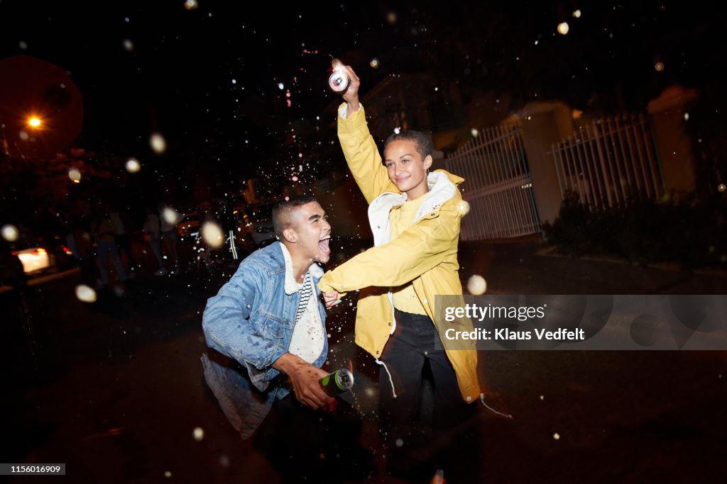 Happy man and woman splashing drink