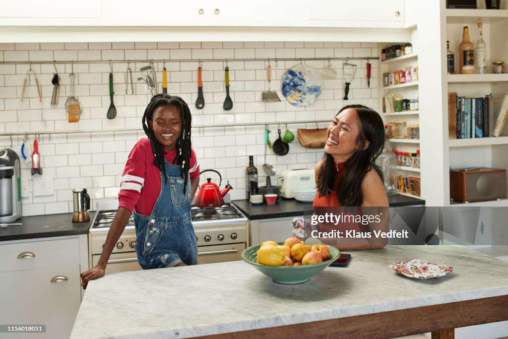 Happy friends at kitchen island