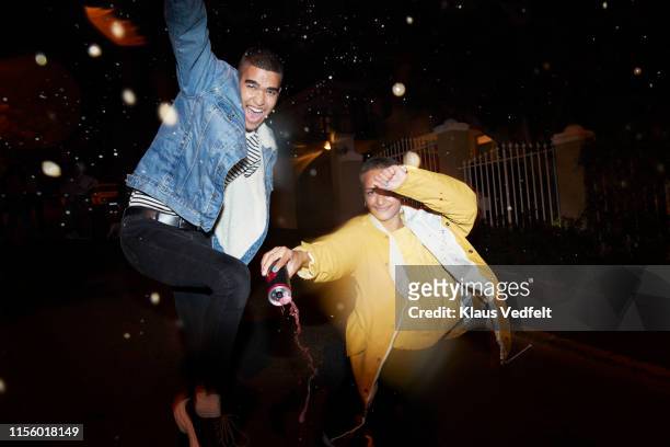happy friends dancing splashing drink - fashion fest 2019 stock-fotos und bilder