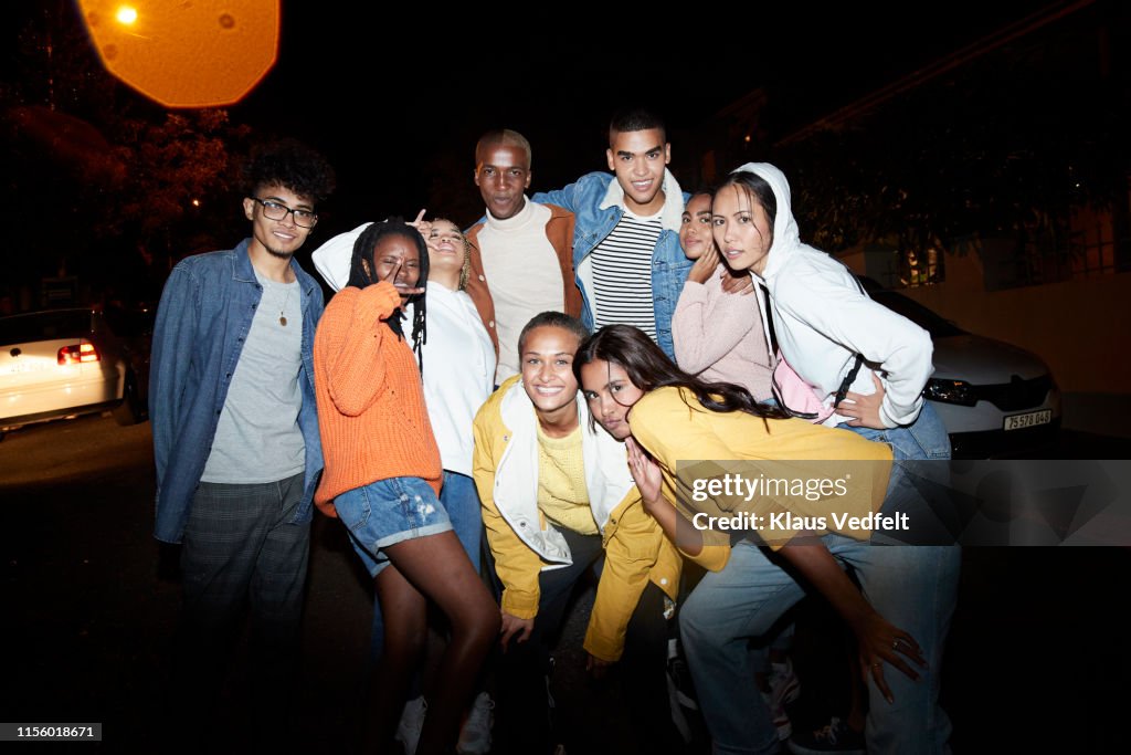 Portrait of friends enjoying on street at night