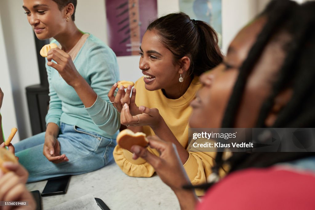 Smiling women enjoying cookies at home