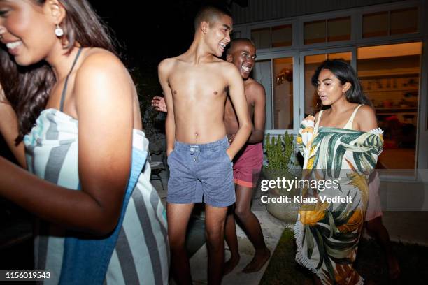 happy multi-ethnic friends in backyard at night - pool party stock pictures, royalty-free photos & images