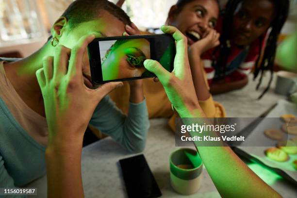 woman photographing female friend's eye on phone - hand on hip bildbanksfoton och bilder