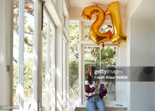 happy woman with 21 shaped balloons at home - number 21 stock pictures, royalty-free photos & images
