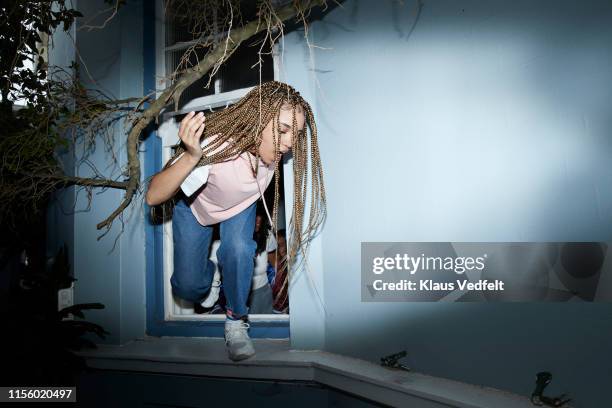 female with long hair jumping out of window - mens long jump stockfoto's en -beelden