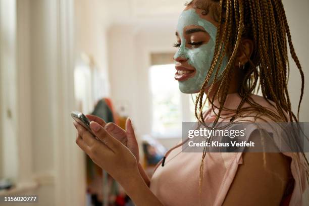 side view of woman using smart phone at home - bleached hair fotografías e imágenes de stock