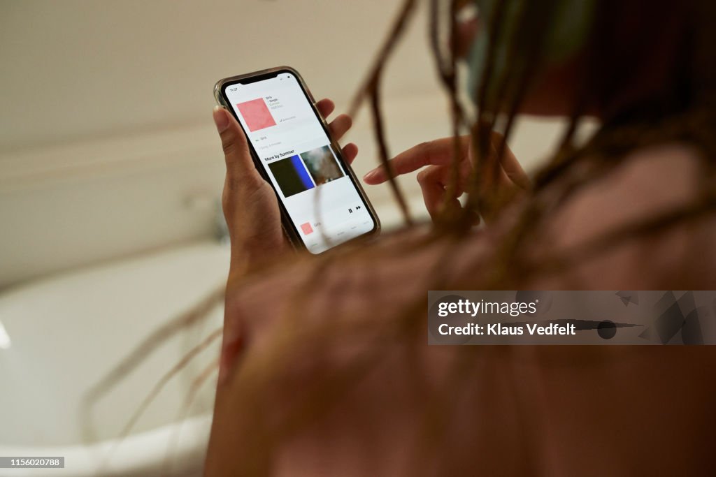 Young woman using smart phone in bathroom