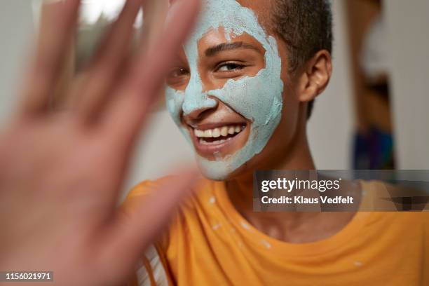 close-up of smiling woman gesturing at home - clay mask face woman stock pictures, royalty-free photos & images