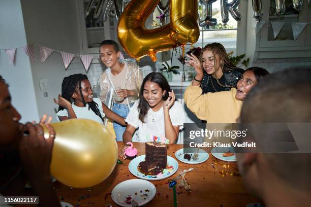 multi-ethnic friends celebrating birthday at home - birthday streamers stock-fotos und bilder