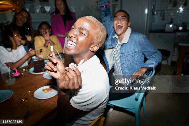cheerful man celebrating birthday with friends - cuisine humour stock-fotos und bilder