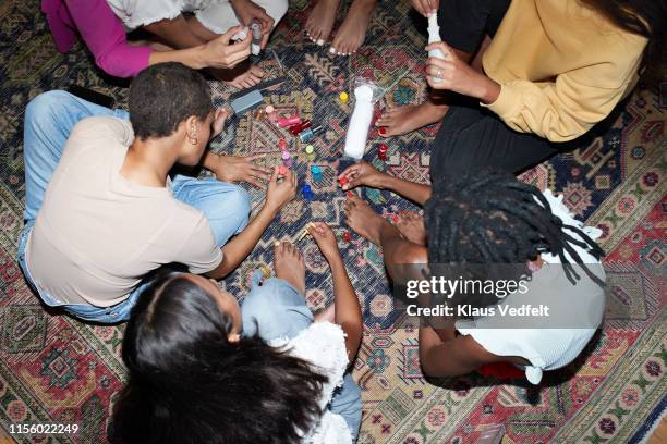 multi-ethnic friends applying nail polish at party - painting fingernails stock pictures, royalty-free photos & images