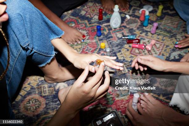 woman holding glitter while sitting with friends - home manicure stock pictures, royalty-free photos & images