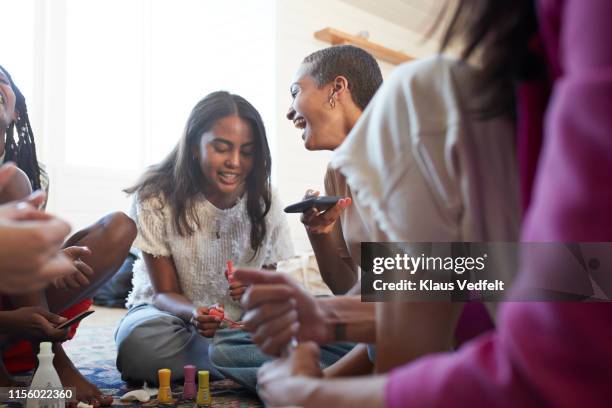 happy friends talking while applying nail polish - manicure stockfoto's en -beelden