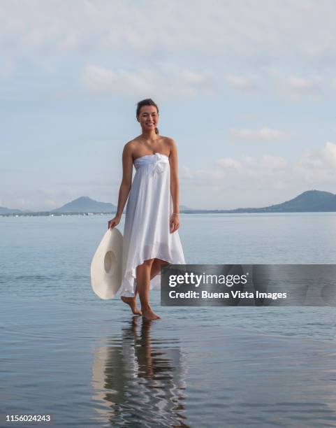 woman walking on edge of infinity pool - strapless dress stock pictures, royalty-free photos & images