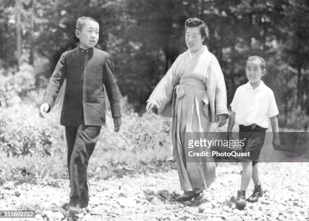Japanese Empress Nagako walks on the grounds of the Gakushuin Peers School with her sons, Crown Prince Akihito and Prince Yashi , Tokyo, Japan, July...