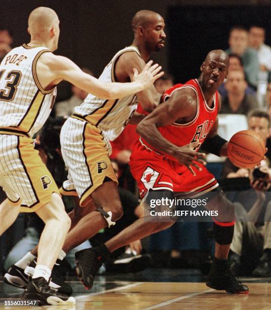 Michael Jordan of the Chicago Bulls is guarded by Derrick McKey and Mark Pope of the Indiana Pacers 23 May during the first half of game three of...
