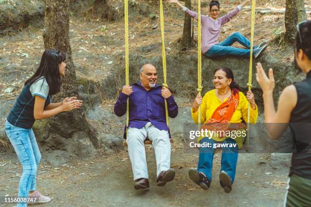 parents of young women swings in their summer vacation. - indian elderly couple stock pictures, royalty-free photos & images