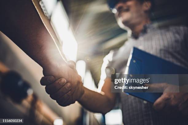 primer plano del inspector estrechando la mano de una persona irreconocible en una fábrica. - reliable fotografías e imágenes de stock