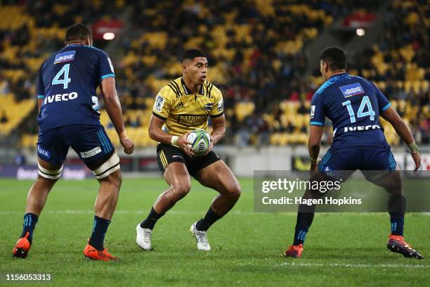 Salesi Rayasi of the Hurricanes attempts to evade Patrick Tuipulotu and Rieko Ioane of the Blues during the round 18 Super Rugby match between the...